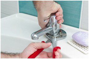 A plumber fixing a tap