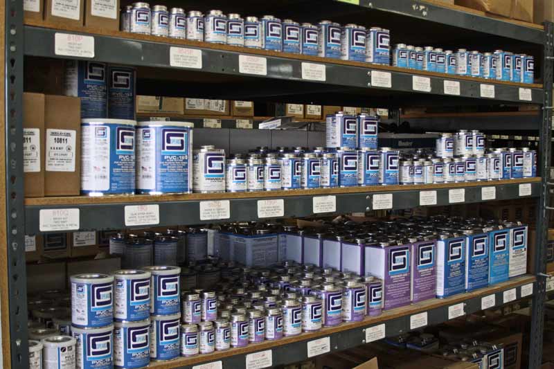 Shelves stocked with cans of paint, various sizes, labeled in blue and white.