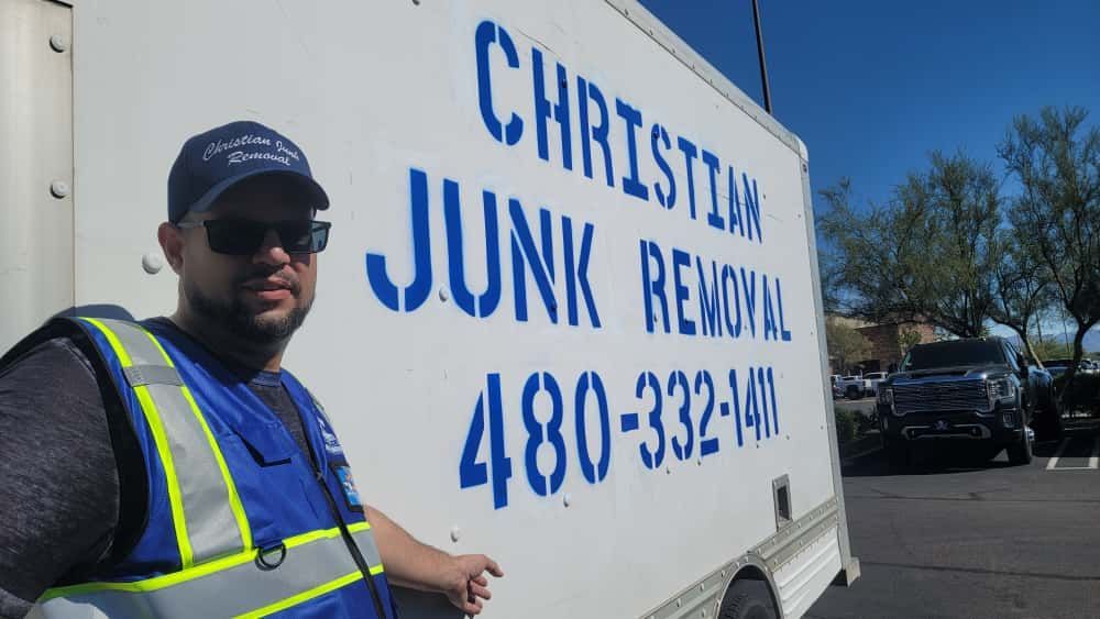 Man in a reflective vest points at a truck labeled 