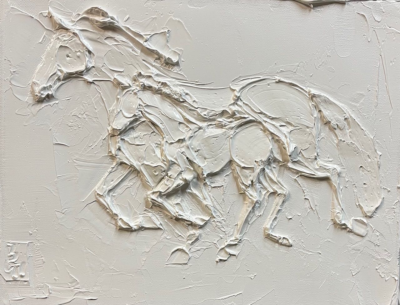 Relief sculpture of a running horse, textured white surface.