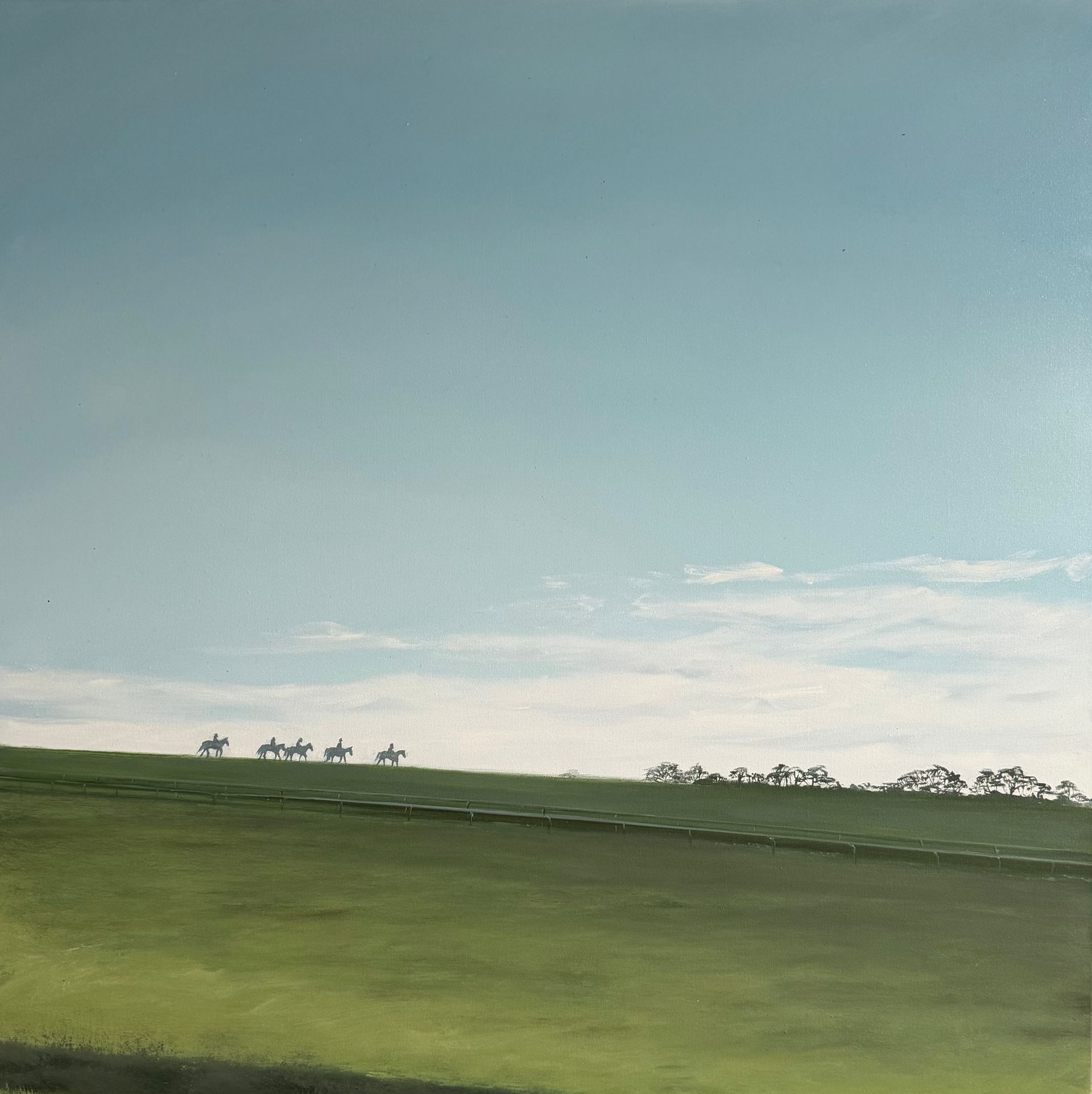 Green field under a blue sky, distant figures on horseback.