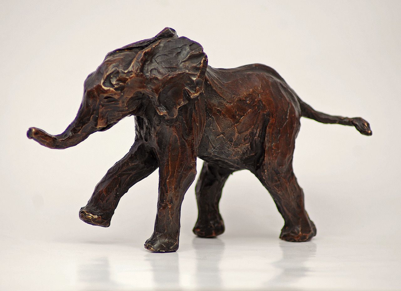 a statue of an elephant with its trunk up