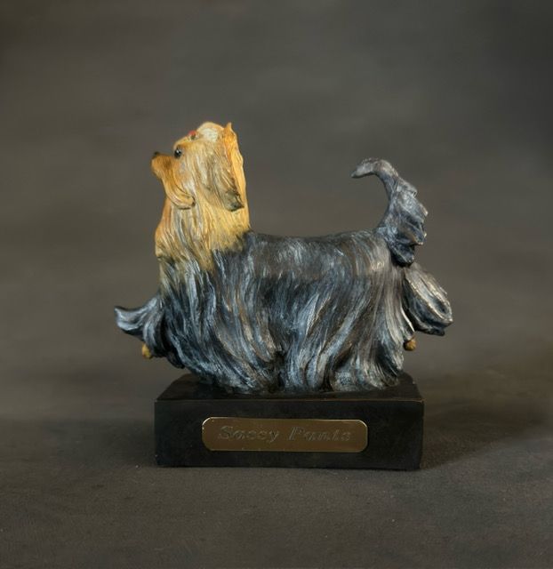 A statue of a yorkshire terrier on a black base