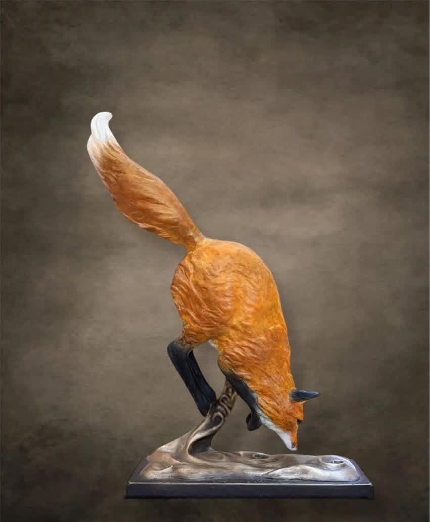 Fox sculpture reaching down towards water, orange fur, white-tipped tail, set against a brown background.