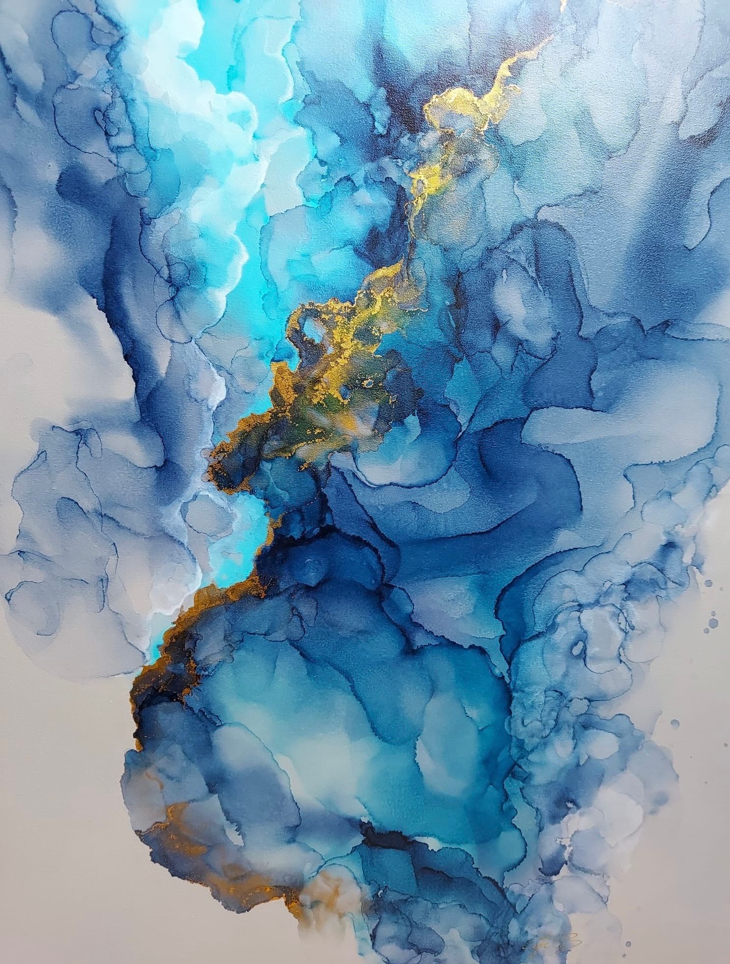 Abstract artwork with swirling blues, gold, and light turquoise ink on a white background.