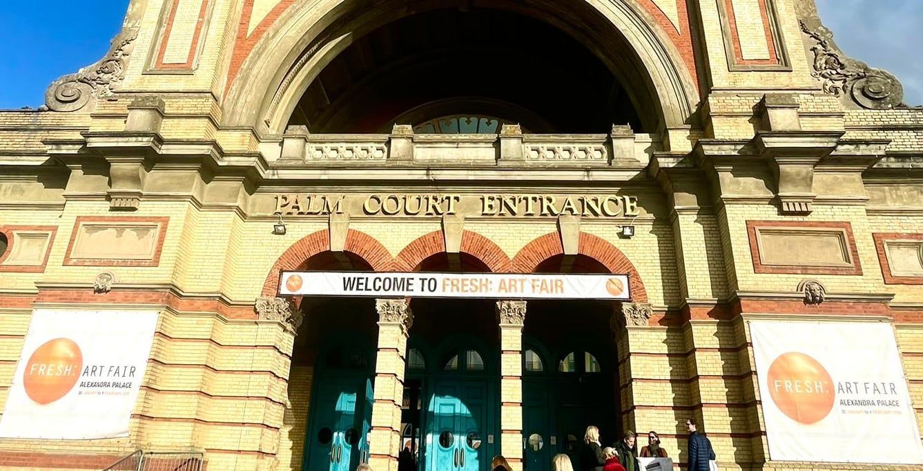 Palm Court Entrance of a Victorian building. Teal doors, orange banner reads 