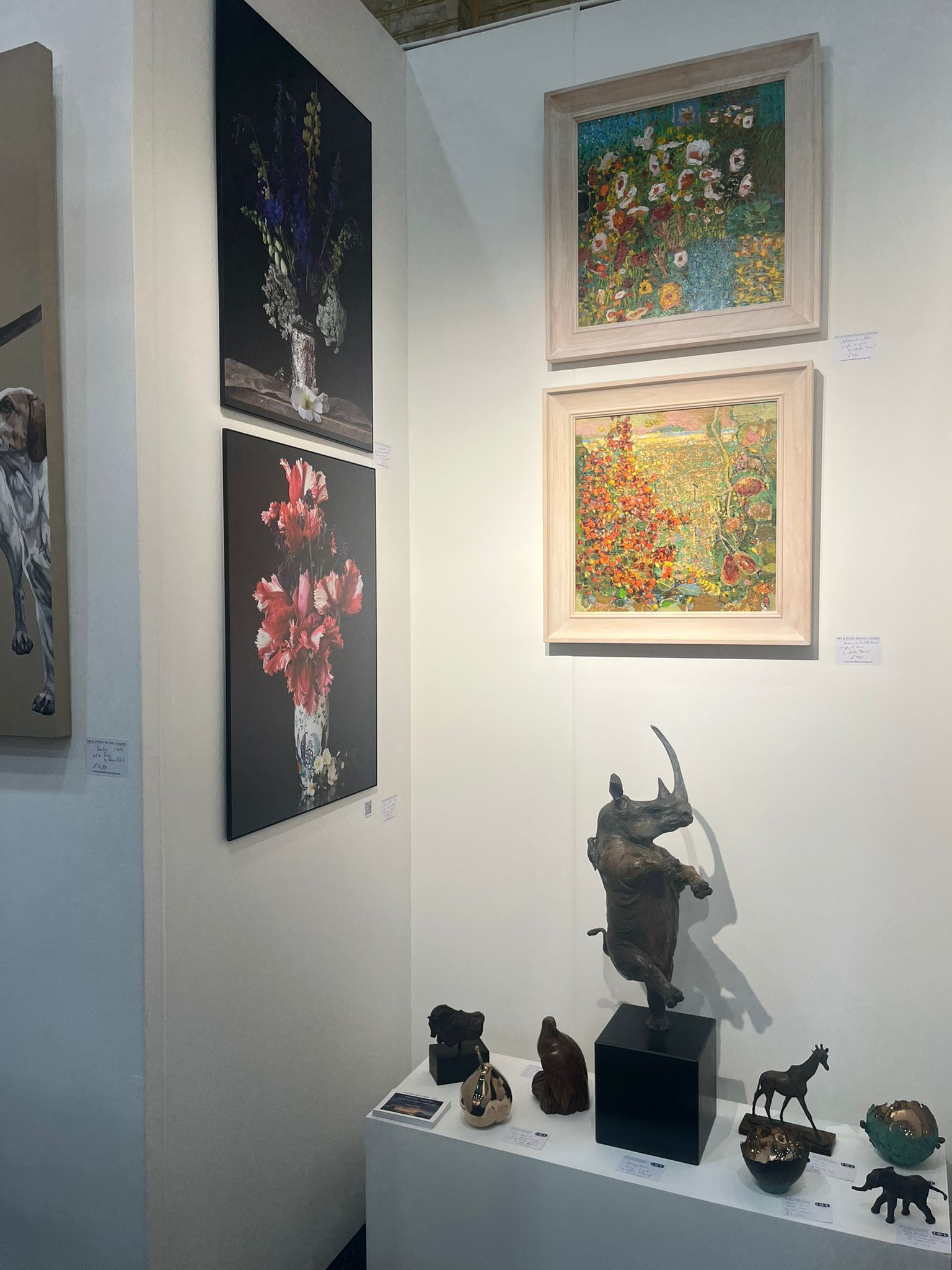 Art gallery corner with paintings and sculptures on display.