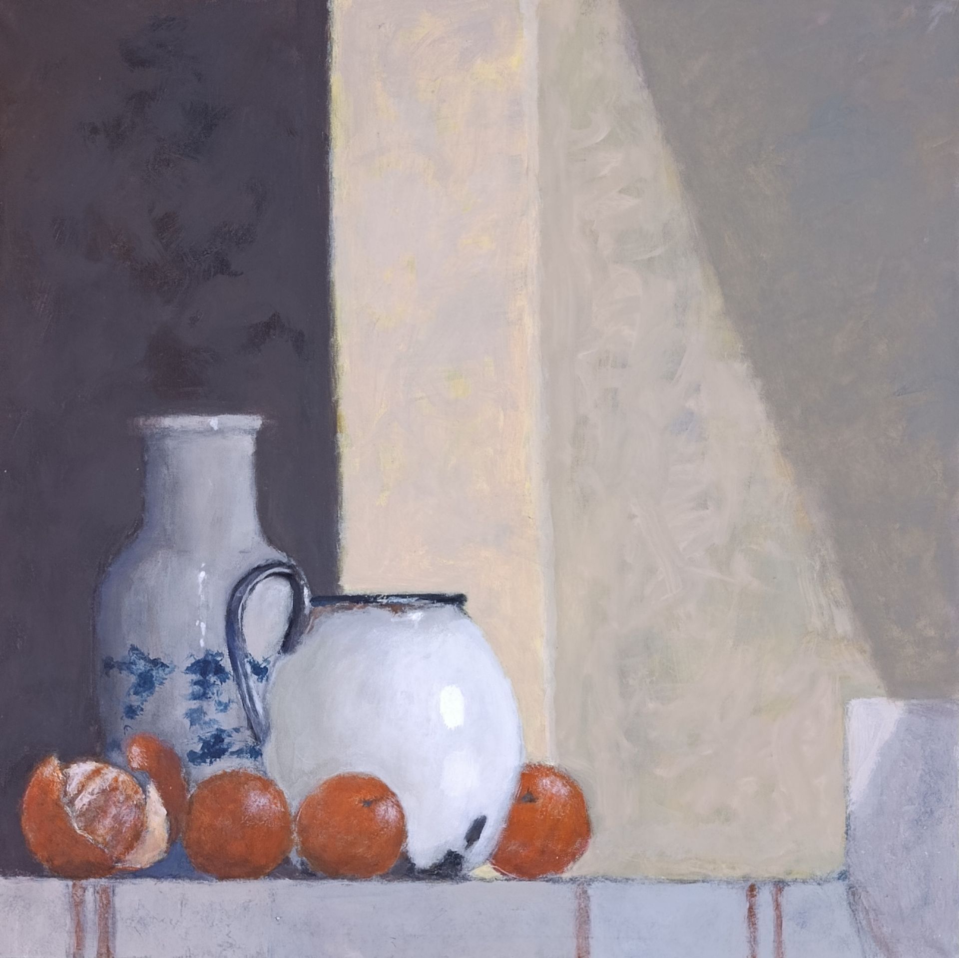 Still life with white pitcher, vase, and oranges on a ledge with a light and shadow play.