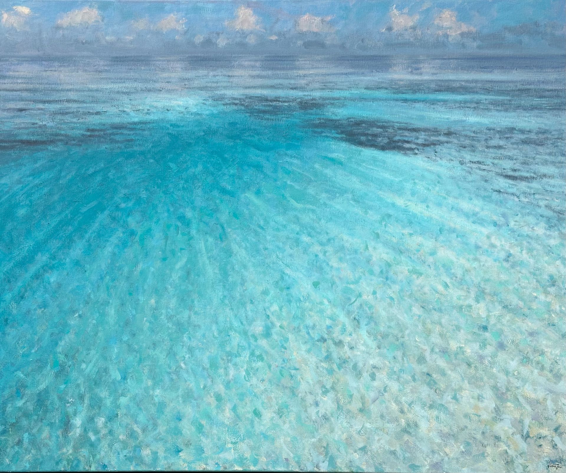 Turquoise ocean water stretching to the horizon under a partly cloudy sky