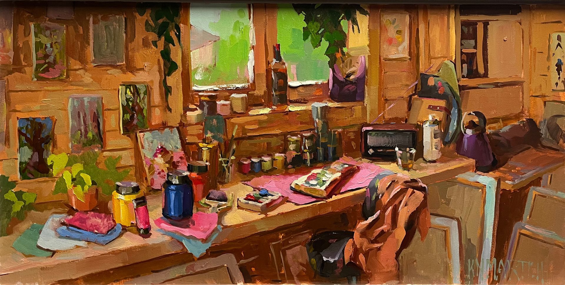 Artist's studio: cluttered desk with paint, brushes, and artwork; sunny window.
