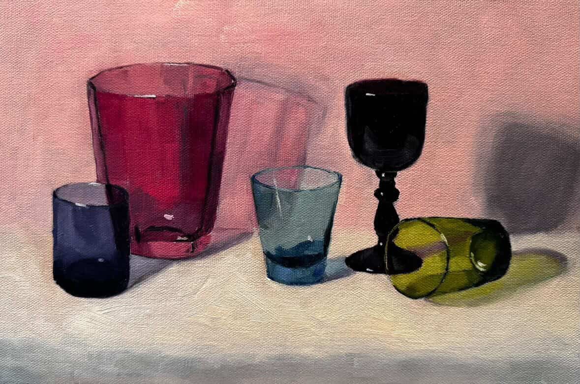 Five colorful drinking glasses arranged on a light surface against a pink background.