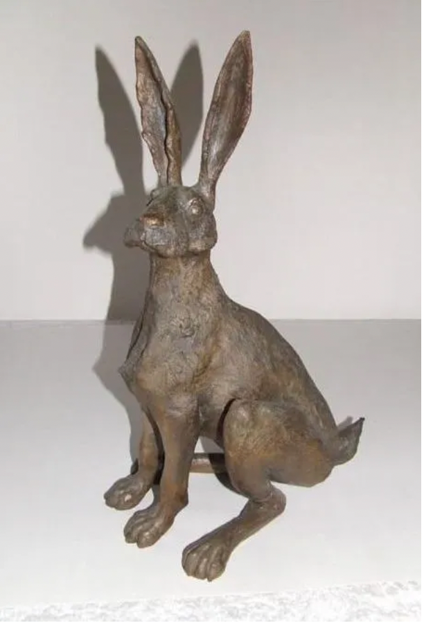 Bronze hare sculpture sitting upright.