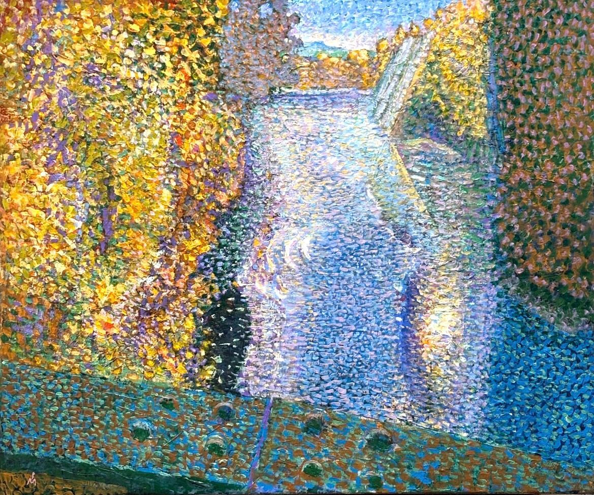 A pointillist landscape of a blue river flowing past lush, yellow-foliaged trees, viewed from a bridge in the foreground.