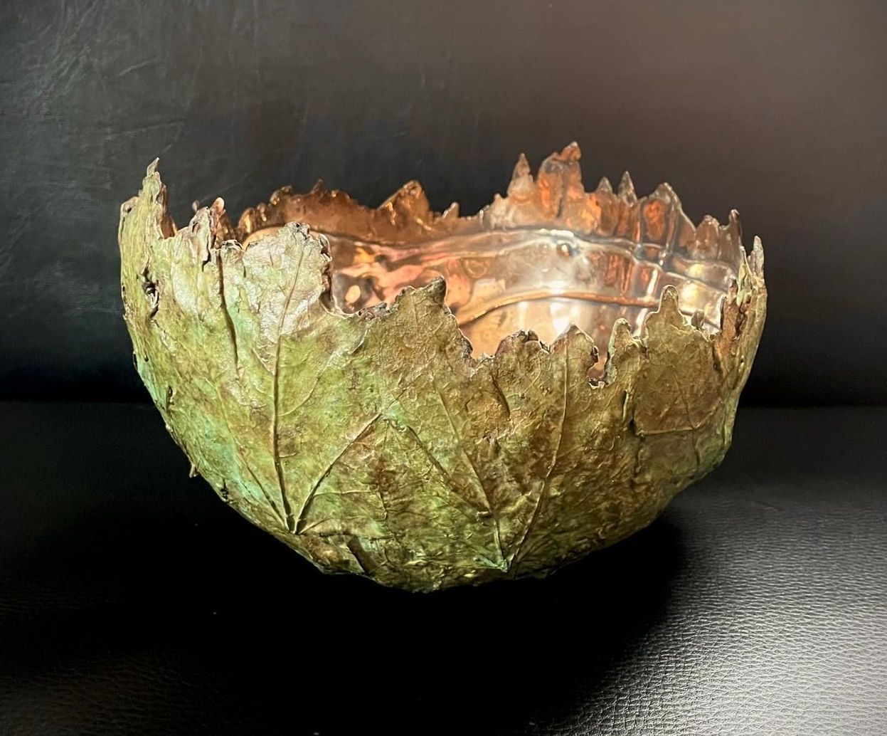 A bowl made out of a leaf is sitting on a table.