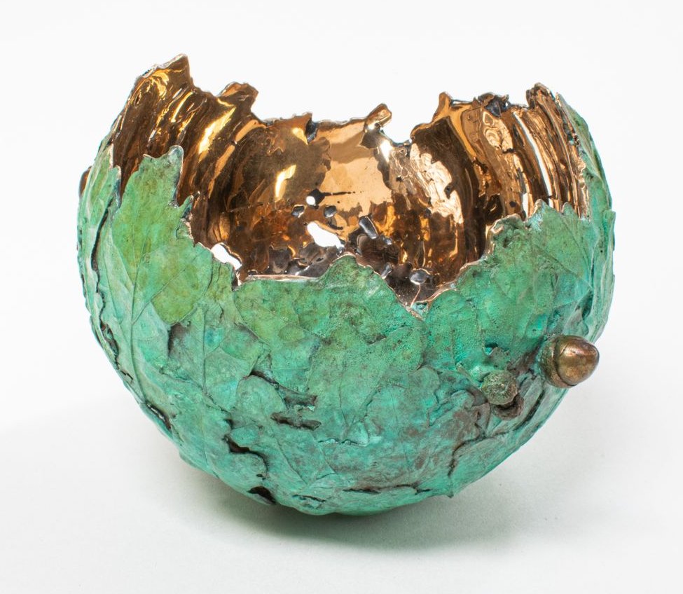 Copper bowl with green leaf exterior and gold interior.
