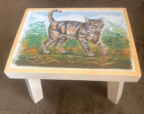 A small table with a painting of a cat on it