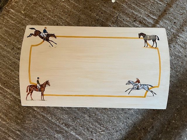 Wooden tray with painted horses and riders on a gold border.