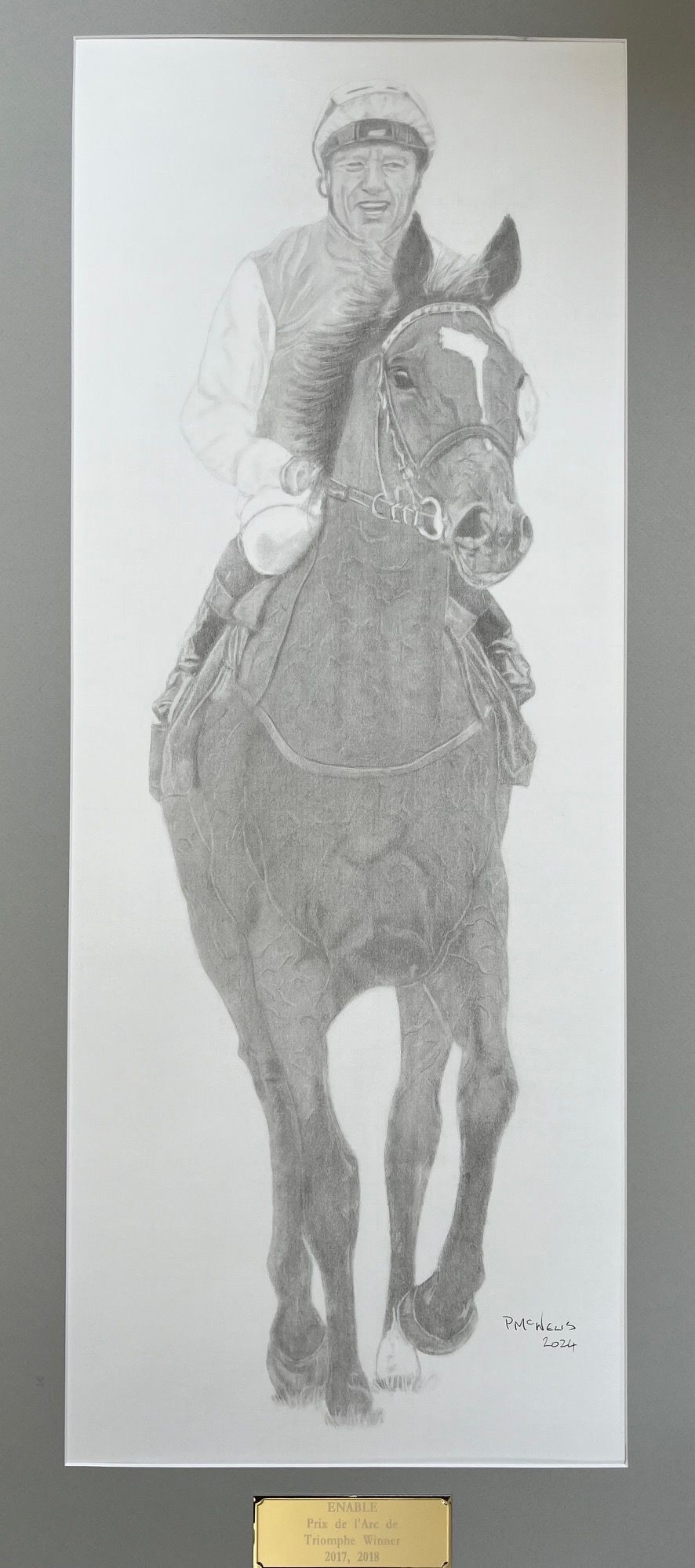Pencil sketch of a jockey riding a horse, framed with a plaque at the bottom.