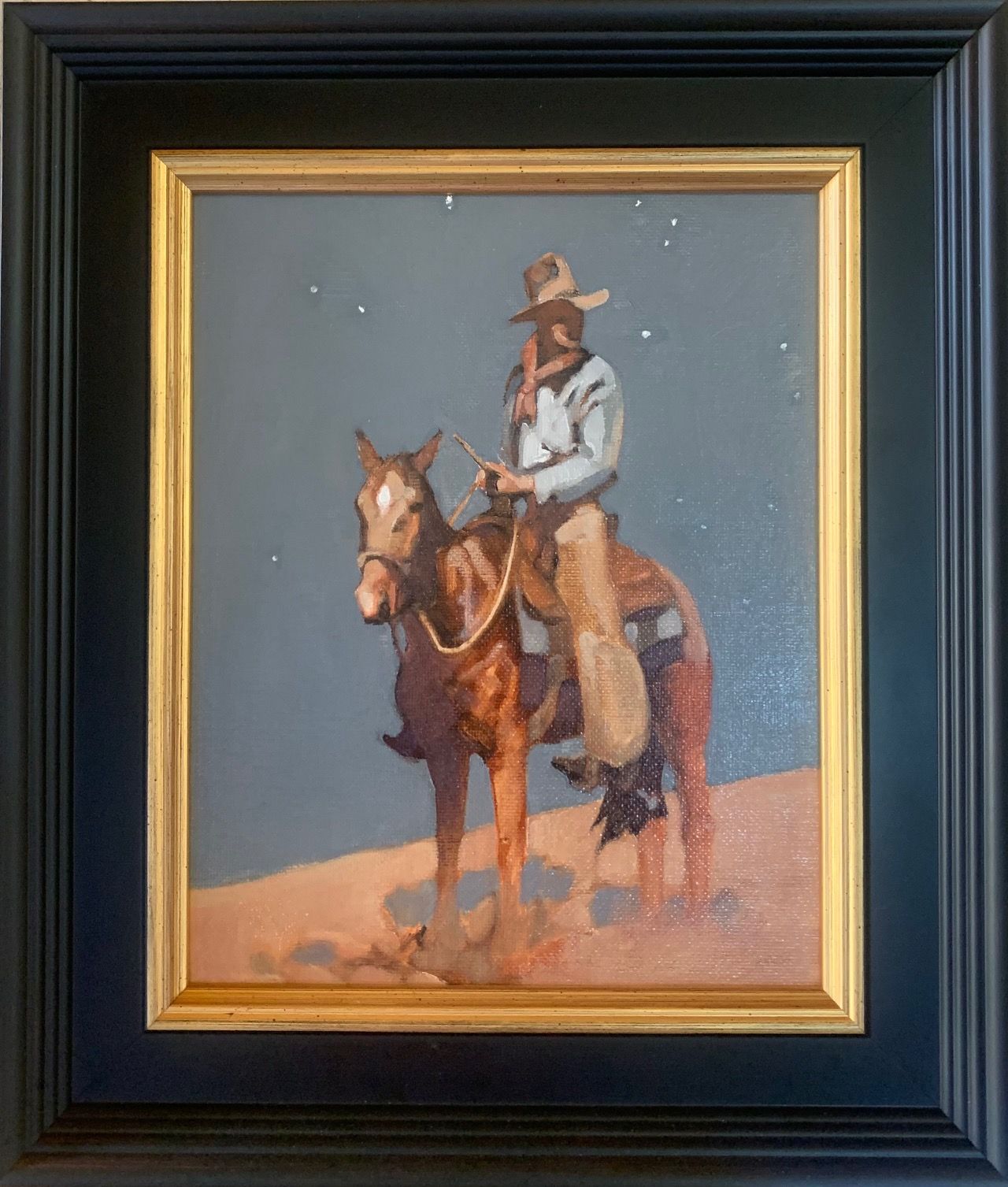 a framed painting of a cowboy riding a horse