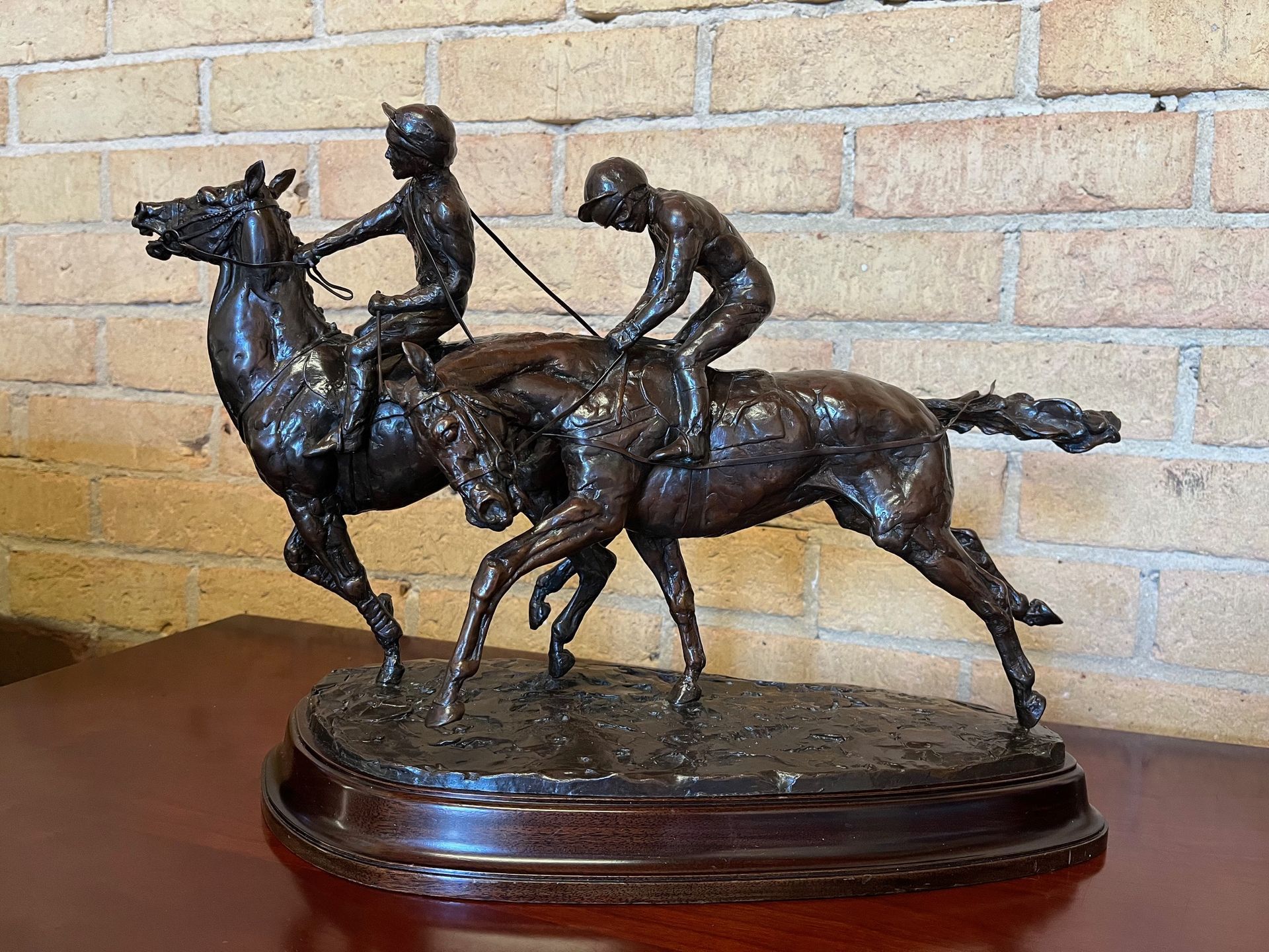 A bronze statue of two jockeys riding horses