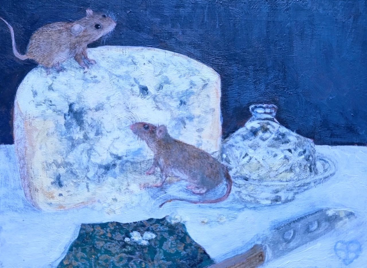 Two mice on a large piece of blue cheese next to a glass dish and a piece of baguette, all on a table.