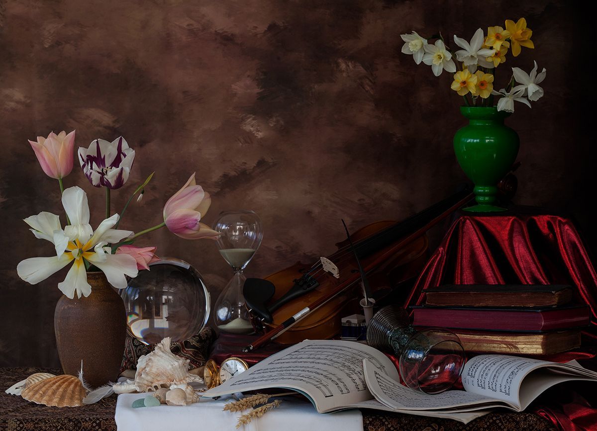 Still life: flowers in vases, books, a violin, shells, and a crystal ball on a table with a dark, textured backdrop.