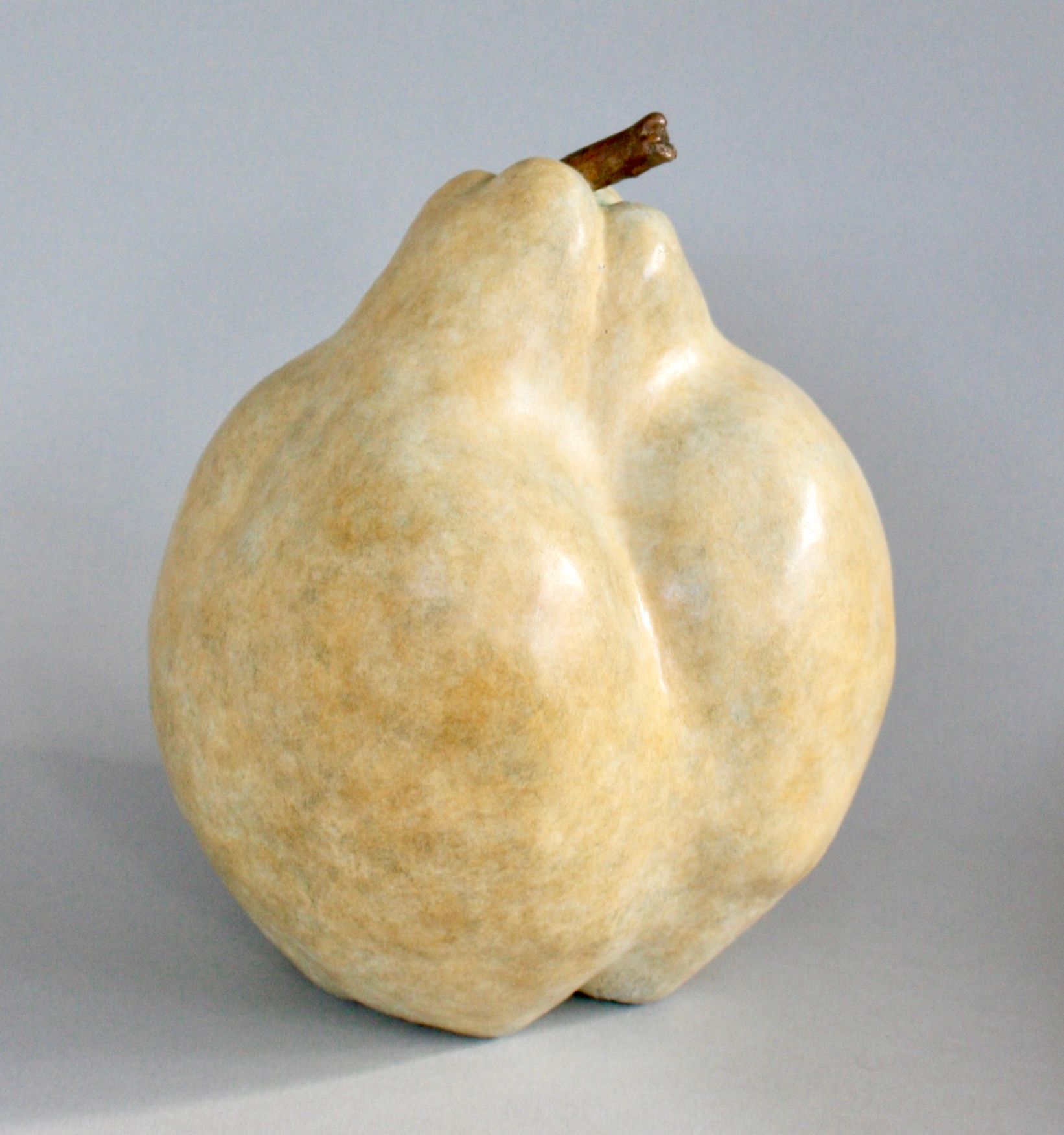 A sculpture of a pear with a brown stem