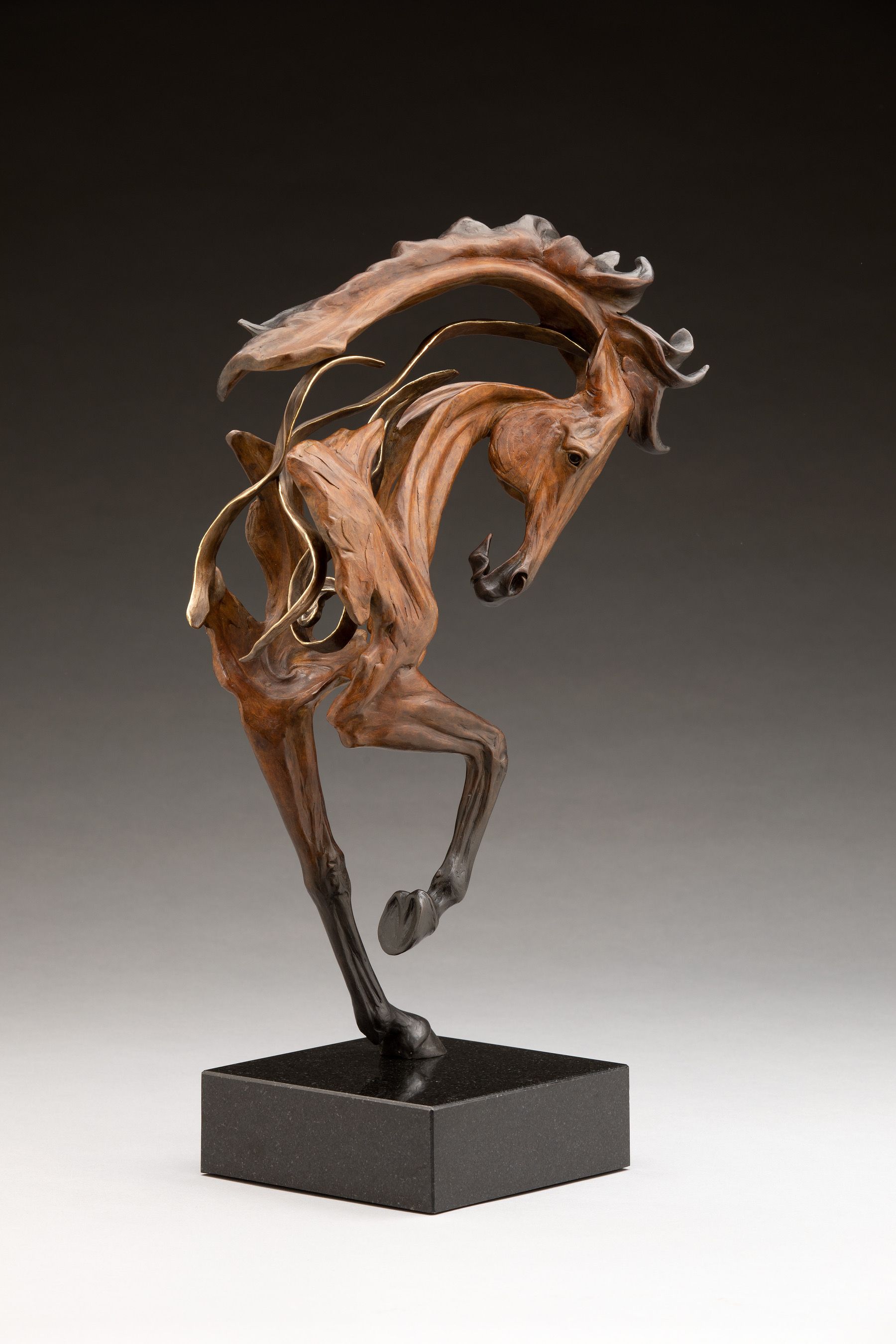 a statue of a brown horse on a black base