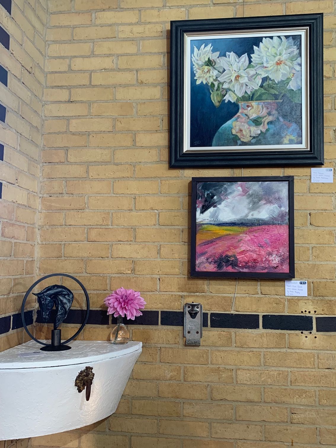 A bathroom with two paintings on the wall