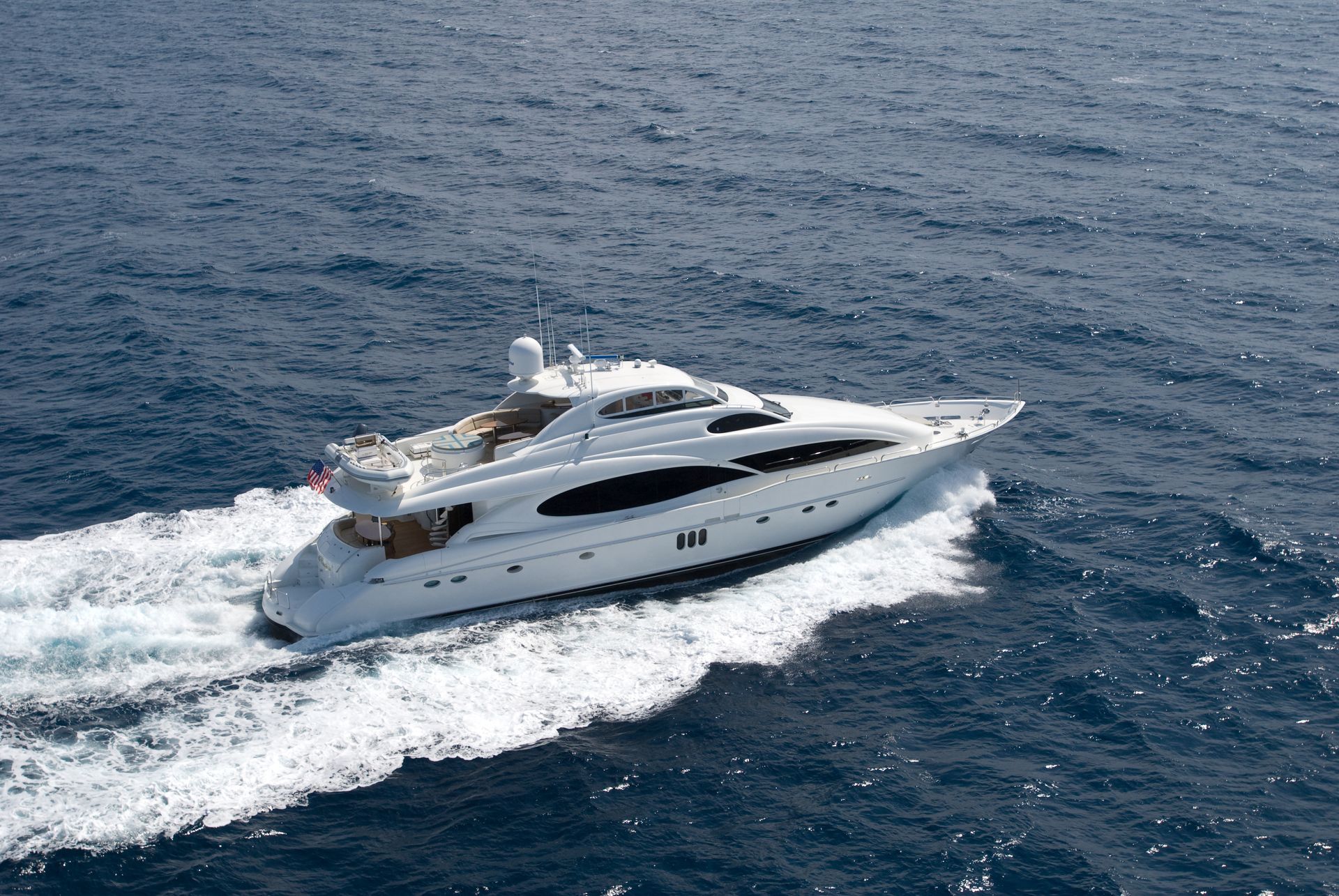 White yacht sailing on blue ocean.