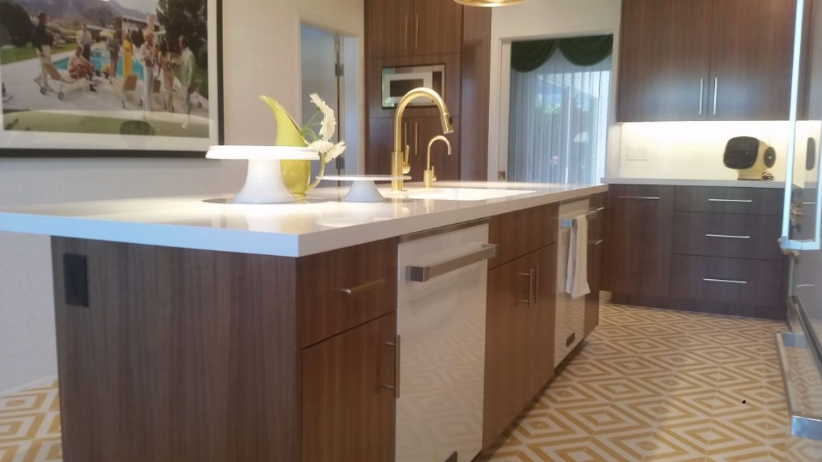 Modern kitchen with large island, white countertops, wood cabinets, and pendant lights
