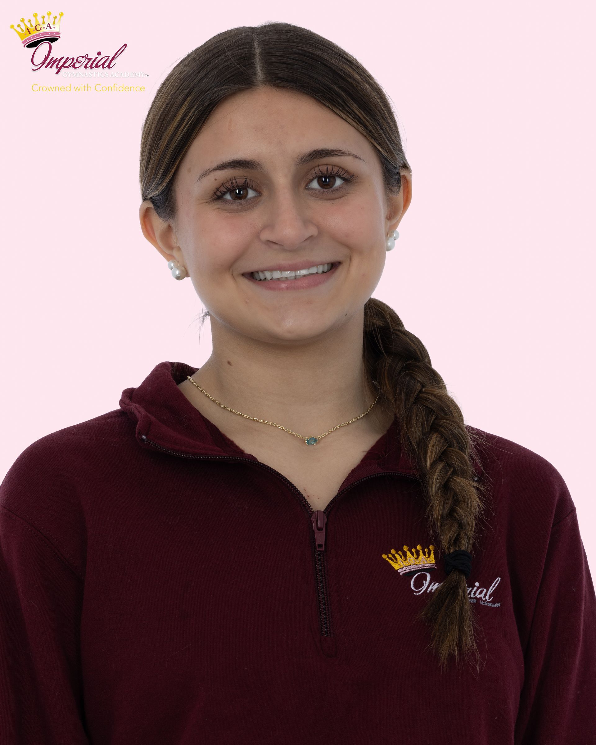 Logo for Imperial Gymnastics Academy, featuring a crown and cursive text in maroon and gold. 