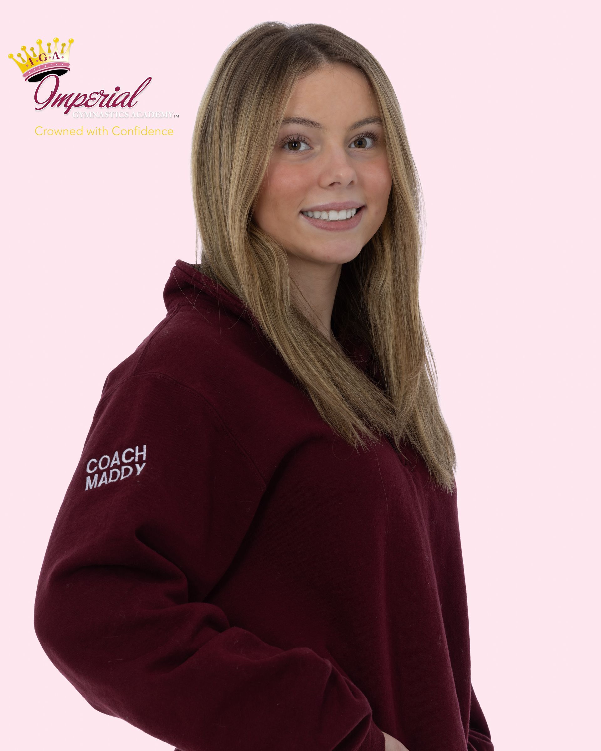 Logo for Imperial Gymnastics Academy, featuring a crown and cursive text in maroon and gold. 