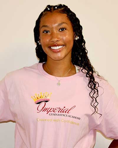 Smiling person wearing a pink t-shirt with