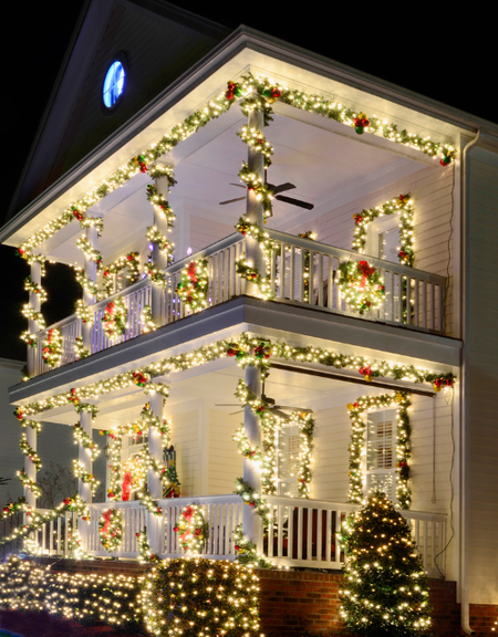 A house is decorated with christmas lights and wreaths