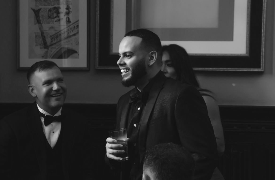 Nova Point Digital founder Edouard Cruz in a tuxedo holding a glass in a black and white photo.
