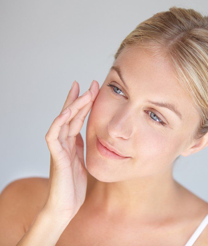 Lady Touching Her Smooth Face — Pensacola, FL — Physicians Cosmetic & Laser Center