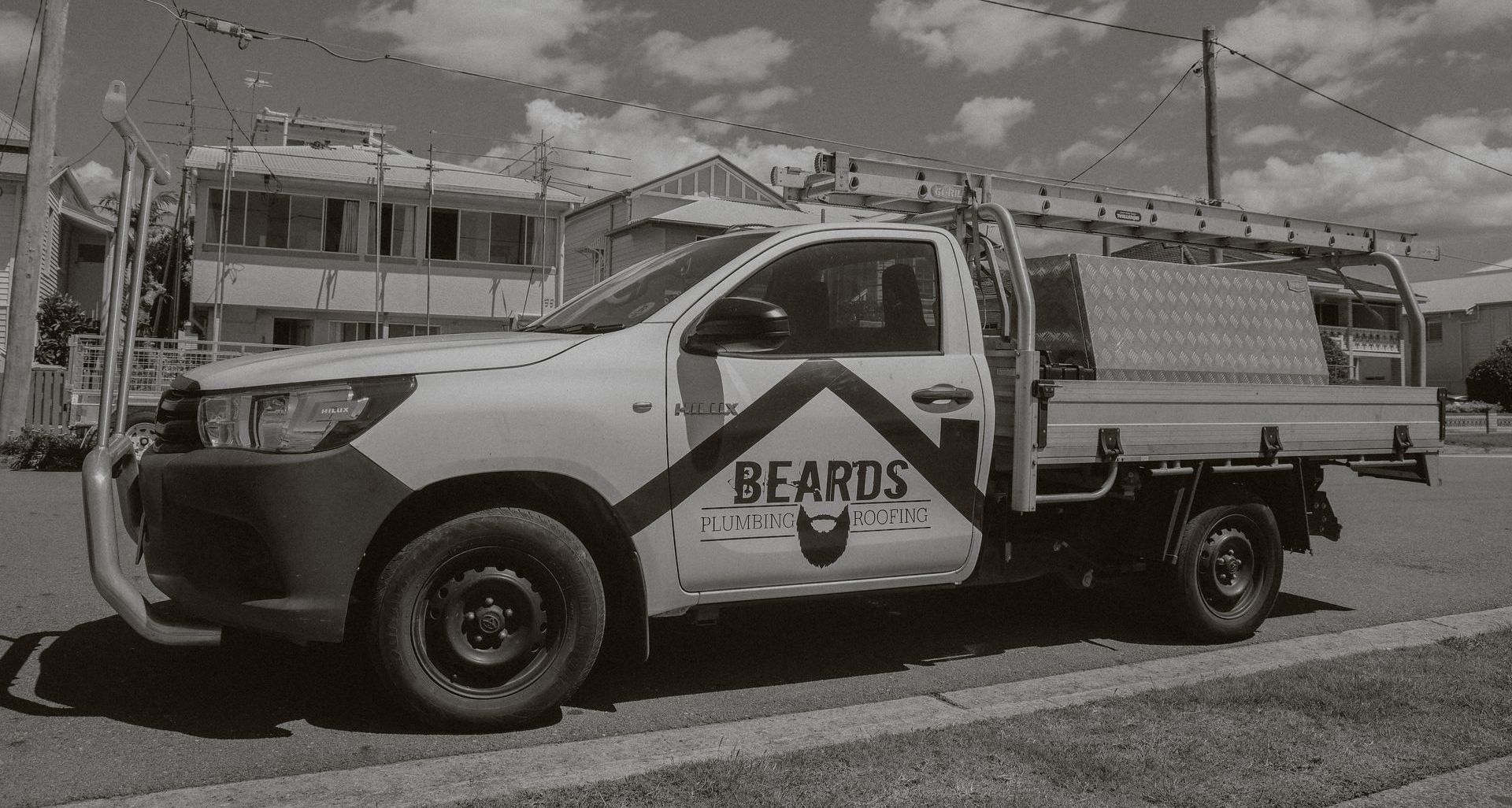 A Black And White Image Of A Plumbing Ute — Beards Roofing and Plumbing in Bribie Island, QLD