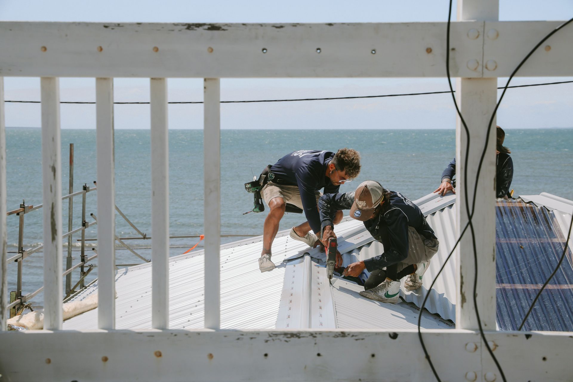 A Group Of Men Completing A Roof Replacement With Colorbond Materials — Beards Roofing and Plumbing in Logan, QLD