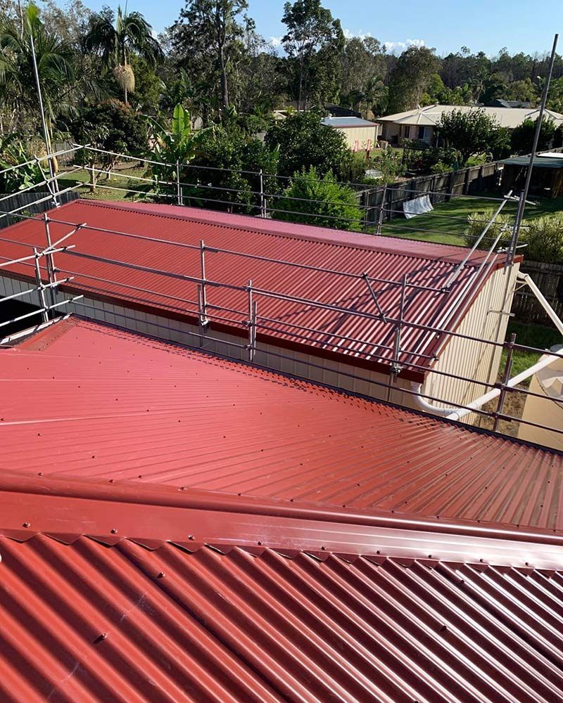 A Red Roof With a Metal Railing on Top of It — Beards Roofing and Plumbing in Bribie Island, QLD