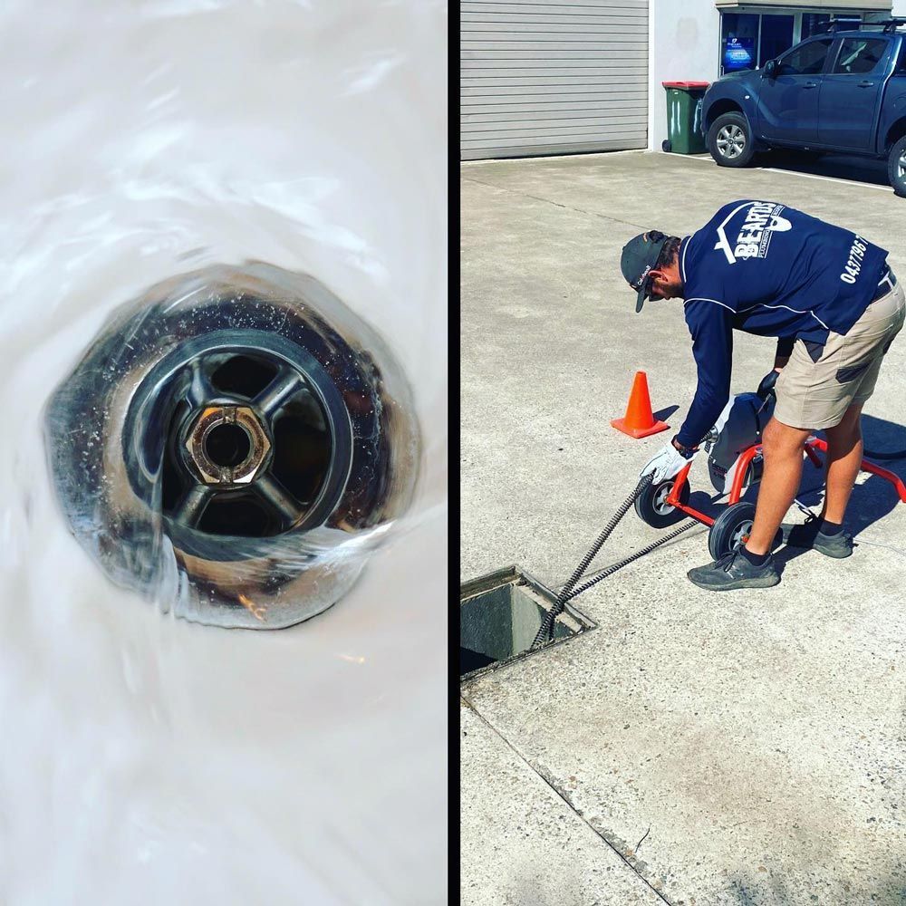 A Man is Cleaning a Drain With a Hose — Beards Roofing and Plumbing in Bribie Island, QLD