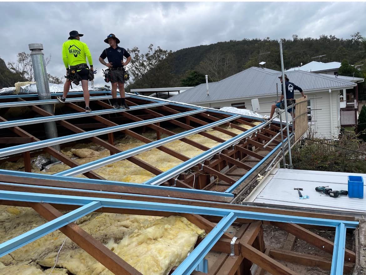 Two Men Are Standing on the Roof of a House — Beards Roofing and Plumbing in Morayfield, QLD
