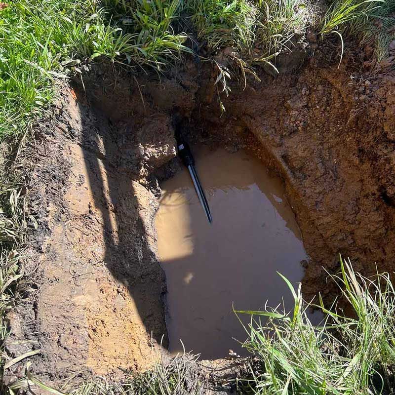 A Hole in the Ground With a Hose Sticking Out of It — Beards Roofing and Plumbing in Bribie Island, QLD
