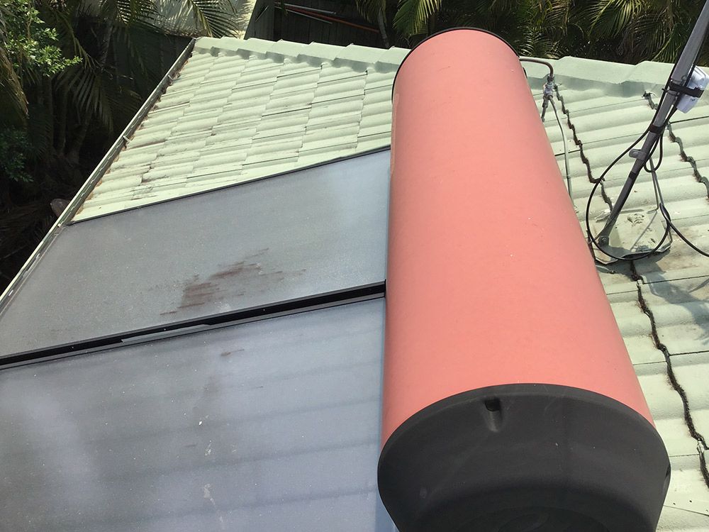A Red Cylinder is Sitting on Top of a Roof — Beards Roofing and Plumbing in Burpengary, QLD