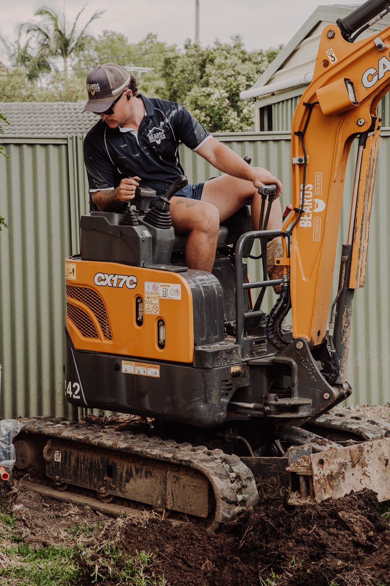 Man is Sitting on Top of a Small Excavator — Beards Roofing and Plumbing in Clontarf, QLD