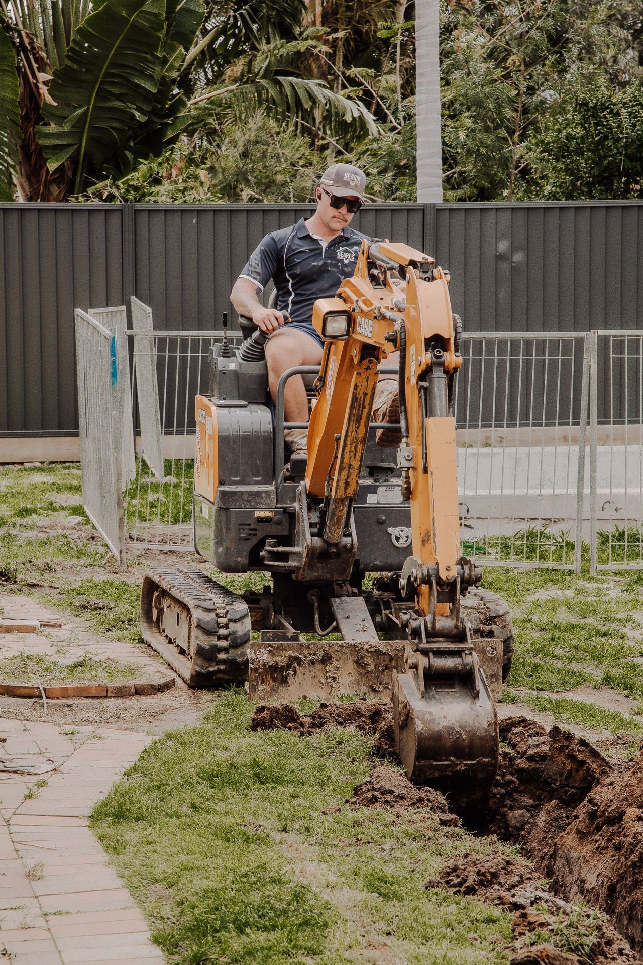 Man is Sitting on a Small Excavator Digging a Hole — Beards Roofing and Plumbing in Clontarf, QLD