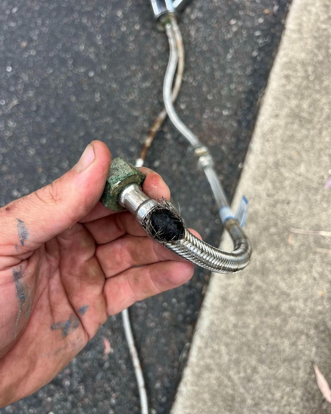 Person is Holding a Hose With a Hole in It in Their Hand — Beards Roofing and Plumbing in Clontarf, QLD