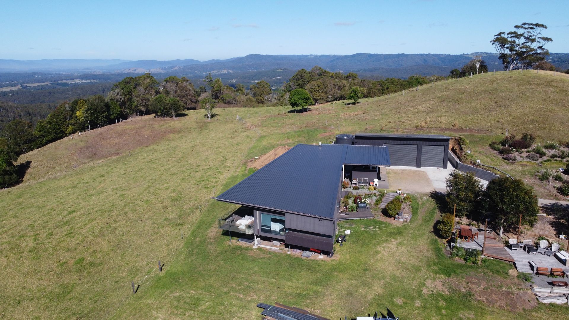 Aerial View of a House on Top of a Grassy Hill — Beards Roofing and Plumbing in Clontarf, QLD