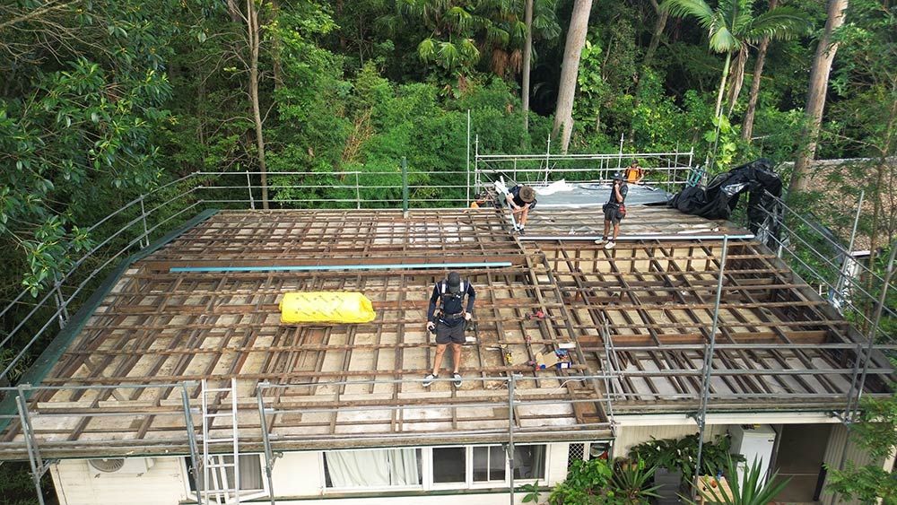 A Group of People Are Working on the Roof of a House — Beards Roofing and Plumbing in Clontarf, QLD