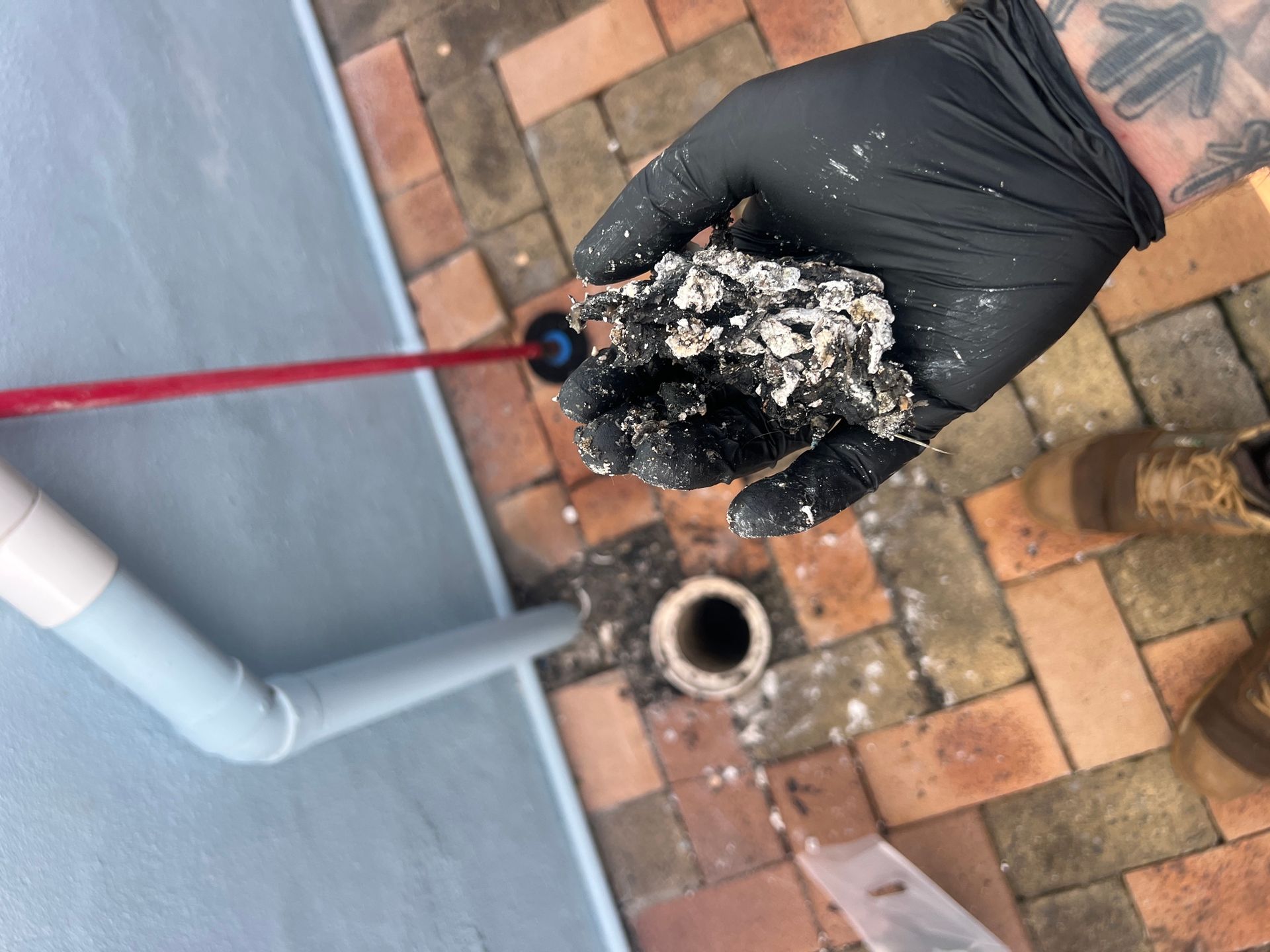 Person Wearing Black Gloves is Holding a Pile of Dirt — Beards Roofing and Plumbing in Clontarf, QLD